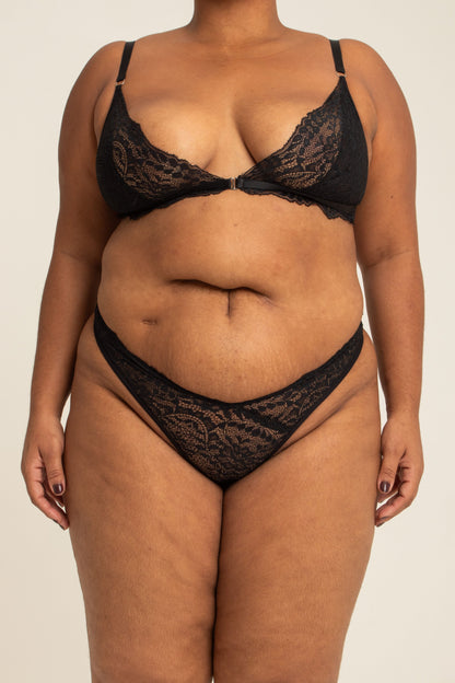 modelo veste calcinha em renda plus size, feita para usar de cintura alta com recortes que estrategicamente deixam o caimento dela perfeito no corpo.