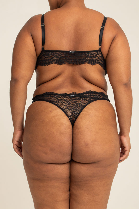 modelo veste calcinha em renda plus size, feita para usar de cintura alta com recortes que estrategicamente deixam o caimento dela perfeito no corpo.