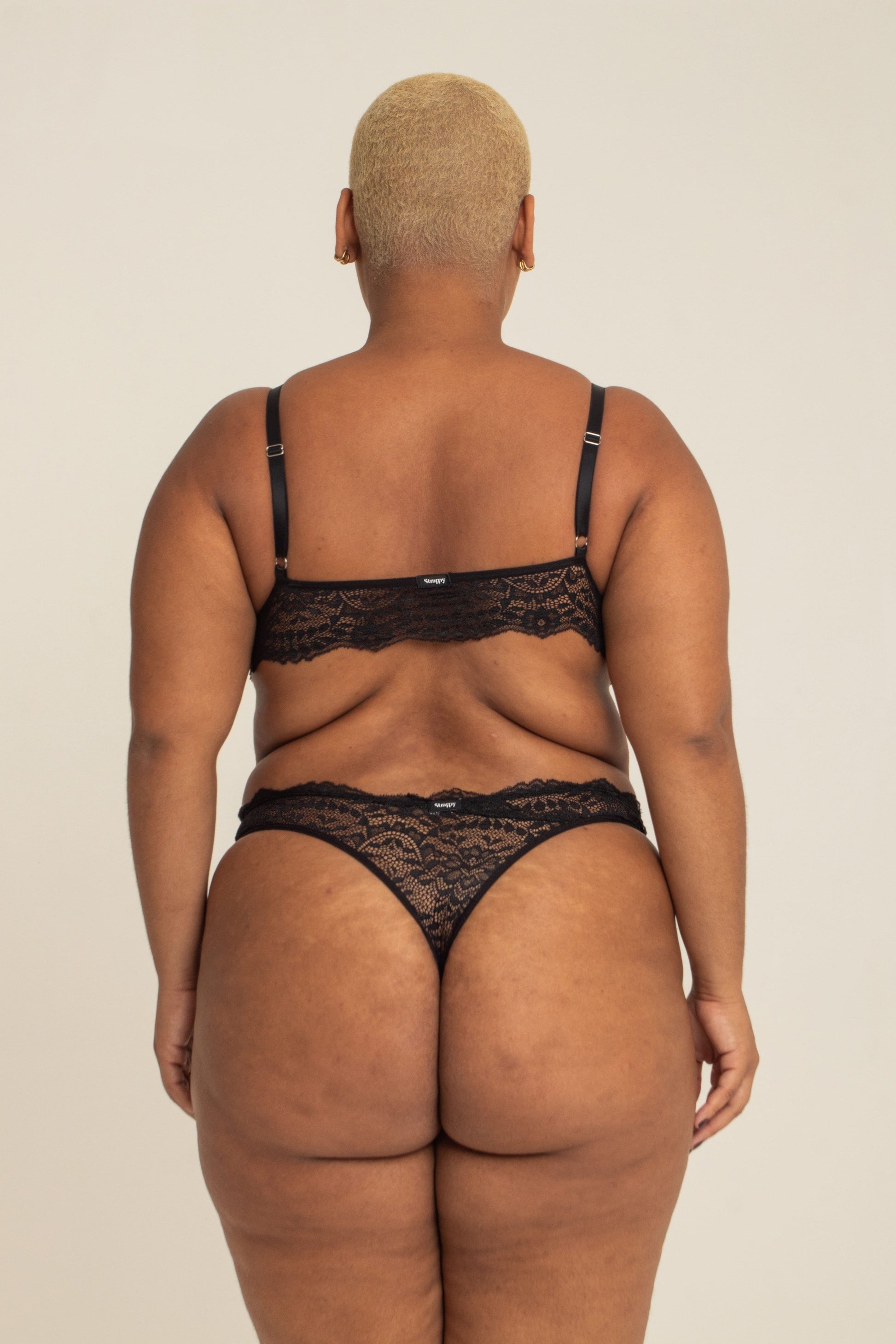 modelo veste calcinha em renda plus size, feita para usar de cintura alta com recortes que estrategicamente deixam o caimento dela perfeito no corpo.