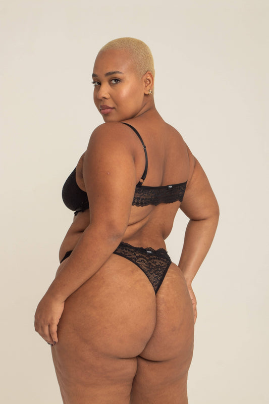 modelo veste calcinha em renda plus size, feita para usar de cintura alta com recortes que estrategicamente deixam o caimento dela perfeito no corpo.