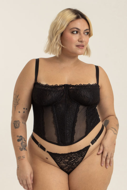 modelo veste corset plus size preto confortável, com renda, recortes e sustentação