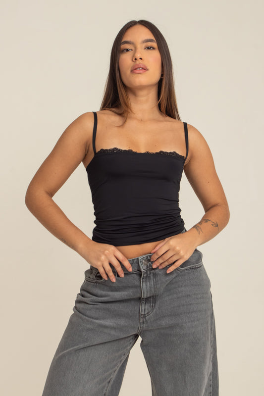 modelo veste regata preta com tecido adaptável ao corpo, super fresquinho e com muita elasticidade