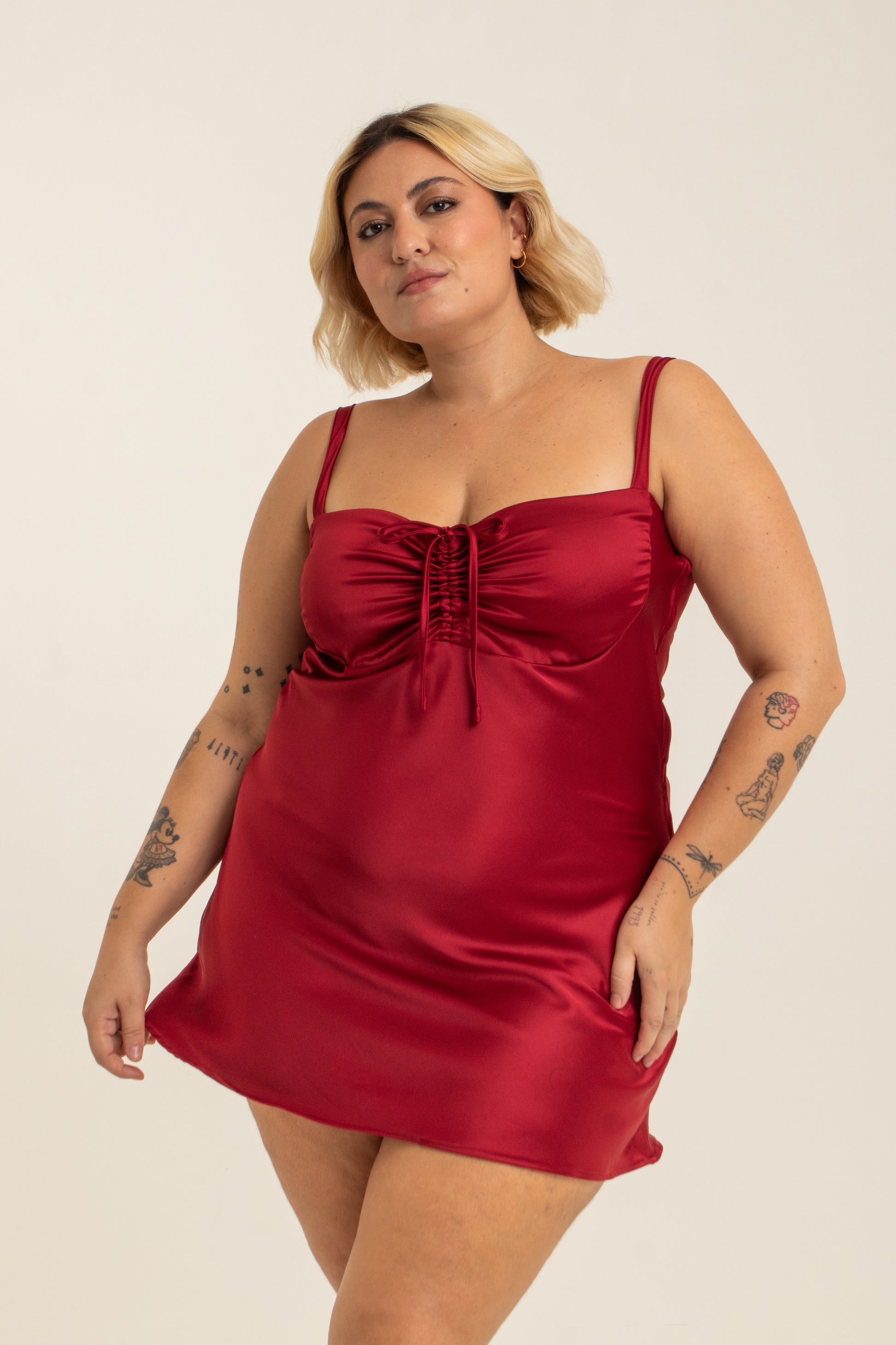 modelo com vestido mini plus size vermelho, todo em cetim. O look perfeito pro seu date