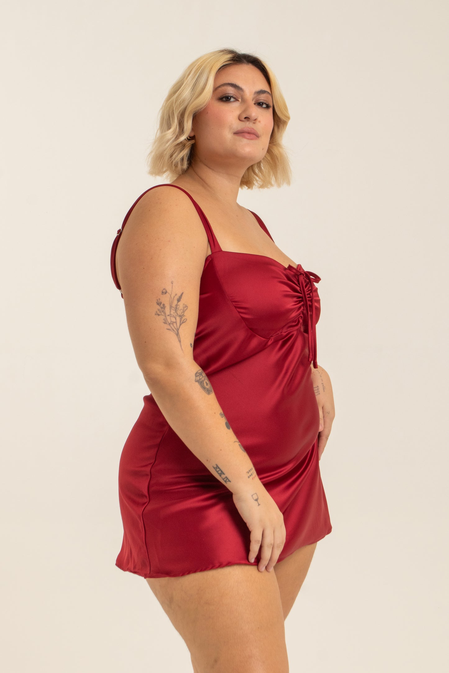 modelo com vestido mini plus size vermelho, todo em cetim. O look perfeito pro seu date