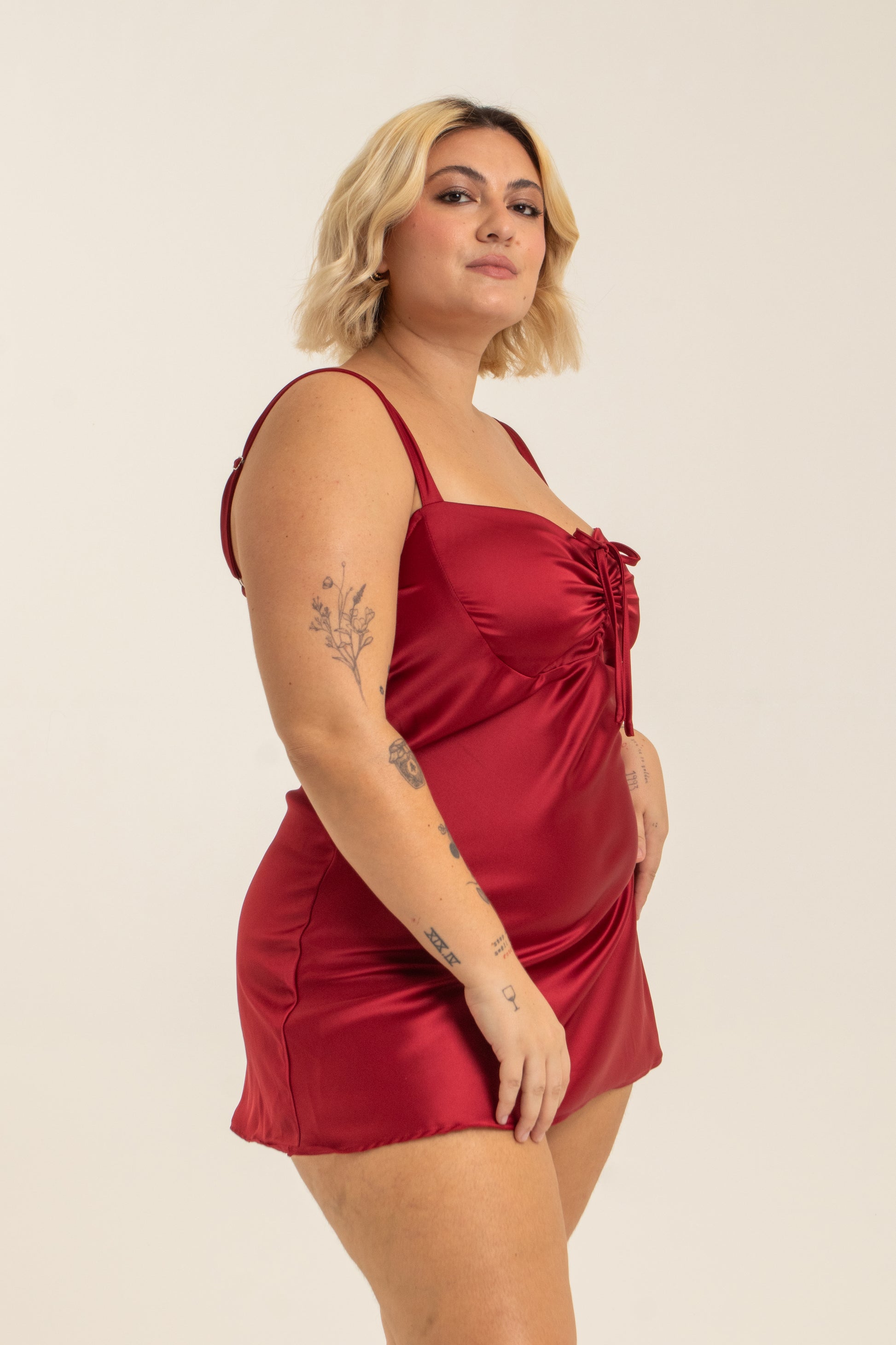 modelo com vestido mini plus size vermelho, todo em cetim. O look perfeito pro seu date